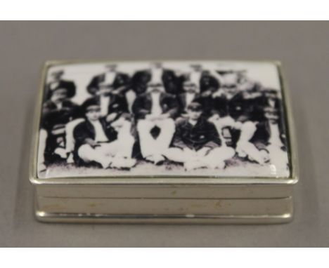 A silver snuff box, the lid inset with a cricket team. 5 cm wide.