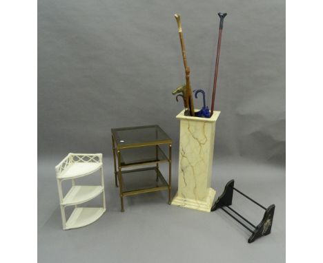 A simulated marble stick stand with walking sticks, a glass etergere, a bookrack and a corner shelf.