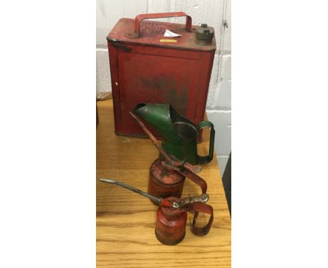 A vintage red painted petrol can, together with others