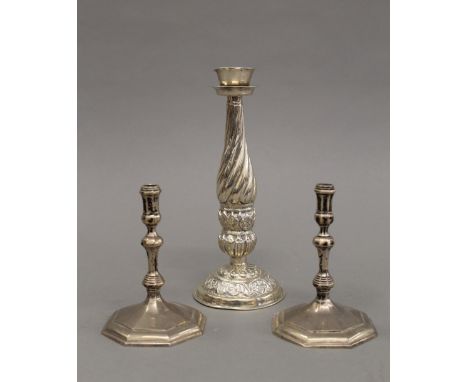 A pair of silver taper sticks and an unmarked Eastern candlestick. The former each 10 cm high. 8.9 troy ounces.