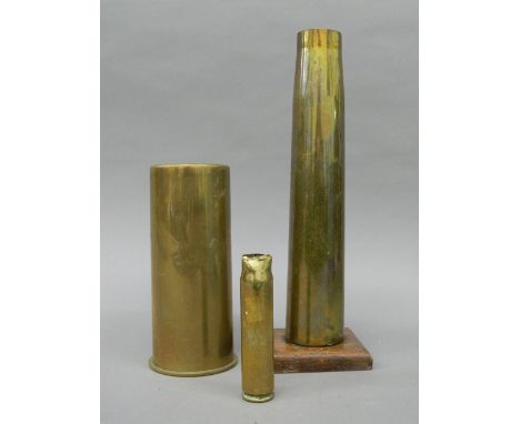 Three vintage artillery shells, one mounted on an oak base. The latter 30 cm high.