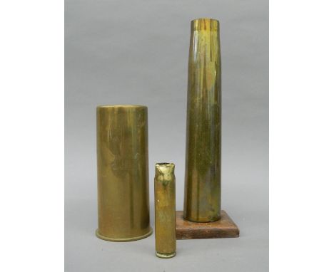 Three vintage artillery shells, one mounted on an oak base. The latter 30 cm high.