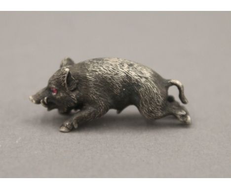 A small silver model of a boar, with gem set eyes, bearing Russian marks. 3.5 cm long.