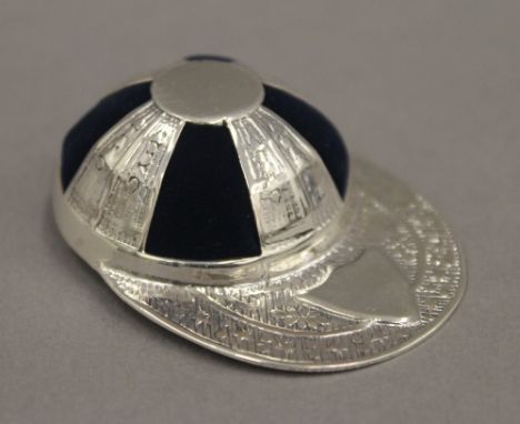 A silver jockey's cap pin cushion. 3.5 cm wide.