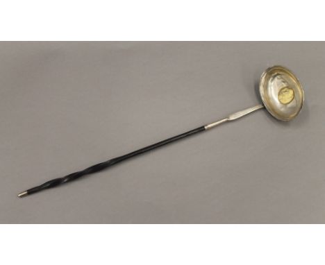 A Georgian coin set unmarked silver baleen toddy ladle.  37 cm long.