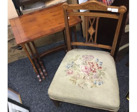 An Edwardian inlaid nursing chair with tapestry seat and original castors, together with a modern nest of three tables. The l