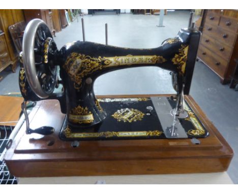 A WOODEN CASED SINGER SEWING MACHINE WITH INSTRUCTION MANUAL 