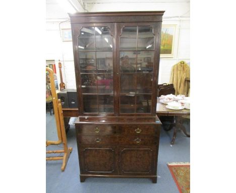 An early 20th century mahogany and walnut fronted side cabinet, the top with twin glazed doors and internal shelves, above a 