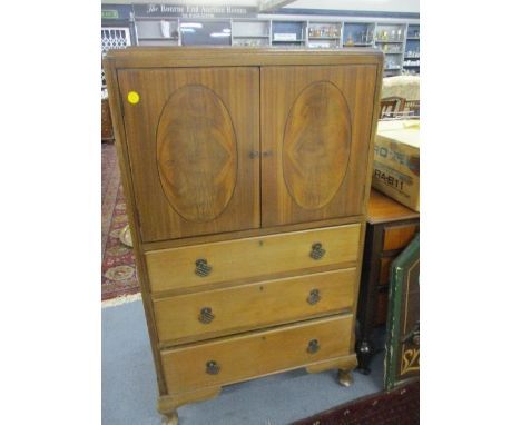 An early 20th century walnut side cupboard having twin doors, above three long drawers, on cabriole bracket feet 