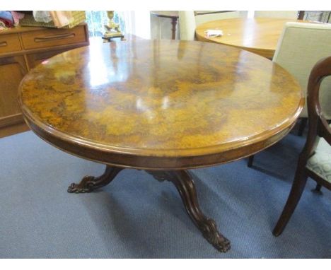 A Victorian walnut dining table with a figured, quarter veneered top, over a carved column on a tripod base, 29" h, 47"w 