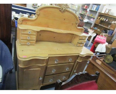 A pitch pine Victorian sideboard with extended back having carved top, single shelf supported by two banks of three drawers, 