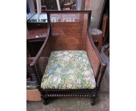 A 1930s oak, cane backed armchair having bobbin turned supports 