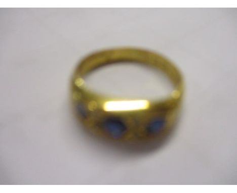 An early 20th century 18ct gold three stone sapphire and diamond chip ring 