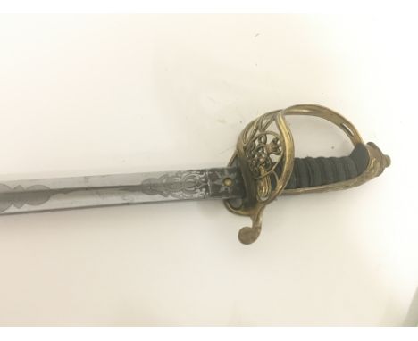 A Victorian brass field officers sword the decorative guard with Victorian cypher and hinge edge engraved blade and brass sca