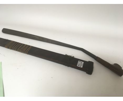 A Mandou tribal head hunters sword with a shaped blade a d wood grip with bound rectangular wood scabbard. Length 70cm.