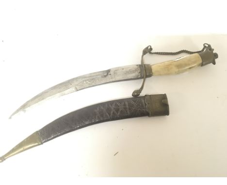 An Indian daggers with bone handle brass mounts and leather scabbard. Engraved blade. Length 31cm