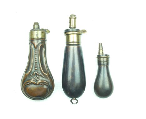 An embossed copper powder flask, with fixed brass top, together with a later revolver or pistol flask with graduated brass to