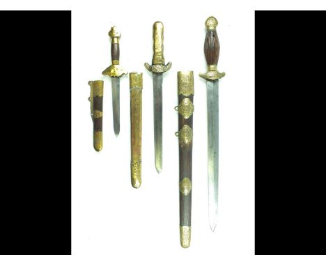 Three various 20th Century Chinese swords or daggers, the first with 39cm flattened diamond section blade, brass hilt decorat