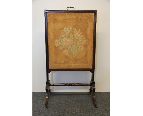 An early 19th century mahogany framed fire screen with adjustable height inner panel and folding reading stand on the reverse