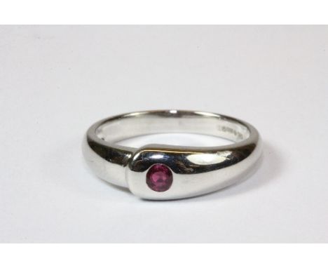 A heavy contemporary platinum ring set with a single ruby in a rub over setting, (P).