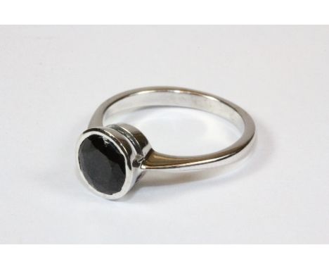 An 18ct white gold ring set with a solitaire sapphire (K).