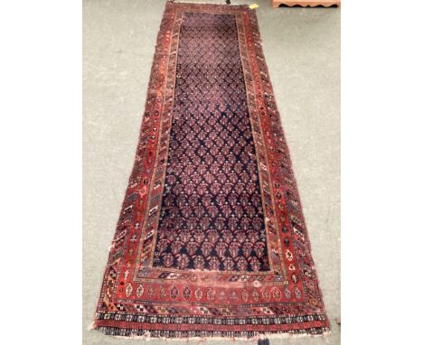 Small Persian style rug runner, with blue and red and all over geometric design, with central panel with blue ground and red 