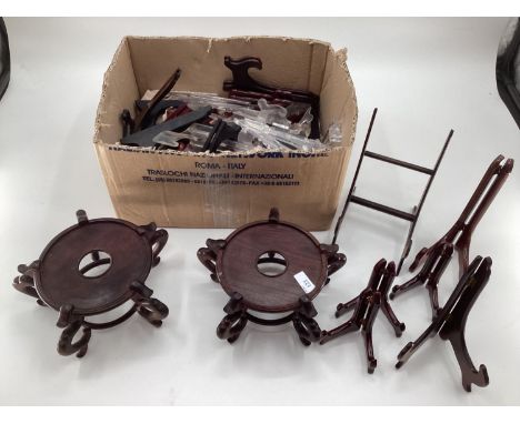 Collection of oriental hardwood stands, and lamp bases, and a quantity of plastic stands 