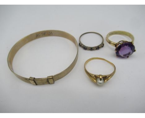 Child's 9ct gold bangle, a 9ct gold solitaire ring with claw set purple stone and two other unmarked gold metal rings gross 1