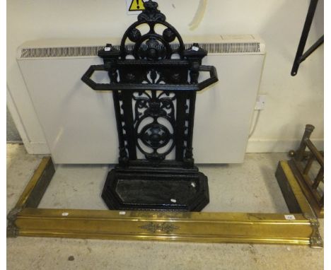 A black painted cast iron stick stand, together with a brass fire kerb