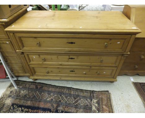 A Continental pine commode of three long drawers on turned feet