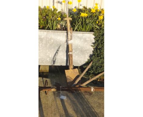 A collection of long handled garden tools and a set of six iron plant supports