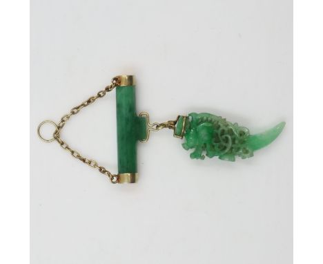 Substantial carved jade pendant, reticulated with the profile of a stylised dragon suspended from a yellow metal mounted jade