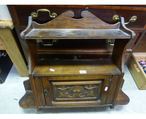 An Edwardian mahogany hanging shelf; with single carved door