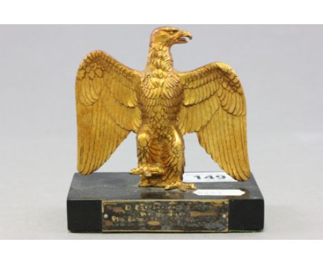 A small gilt model of an eagle on a rectangular slate base; bearing presentation plaque