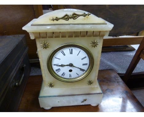 A 19th century alabaster mantle clock; in the Egyptian revival style; the white enamel dial with black Roman numerals; raised