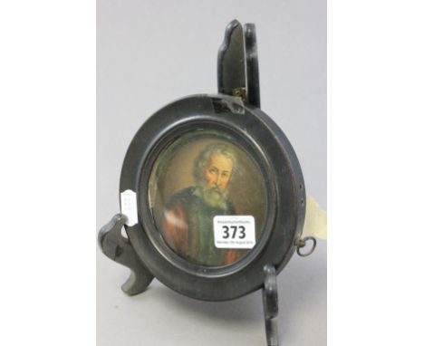 A small Georgian painted papier mache lid; painted with a portrait of elderly bearded gentleman; in a circular ebonised frame