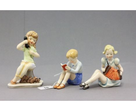 Three Goebel porcelain figures of children comprising; a boy reading a book; impressed to 216 to base; a girl on the telephon