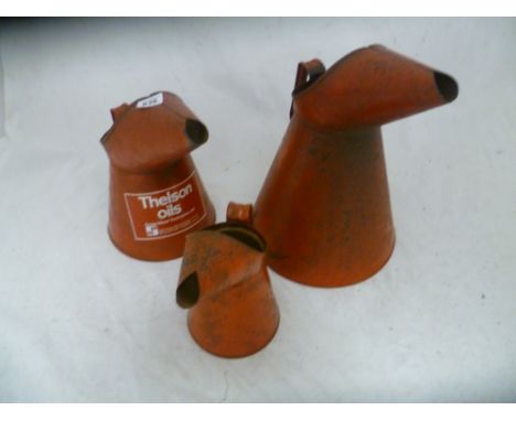 3 graduated vintage red oil jugs