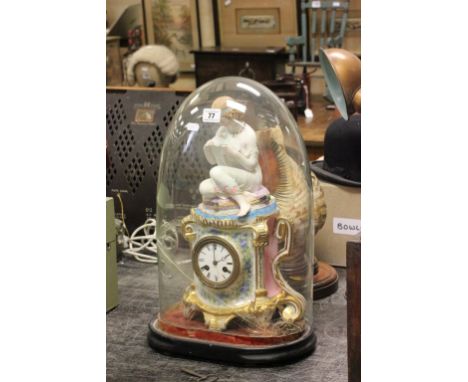 A late 19th century possibly German porcelain mantle clock; surmounted with a seated lady reading a book; with a bird on her 