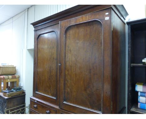 A George III mahogany linen press; with two panel doors; above two banks of five drawers; raised on a plinth base