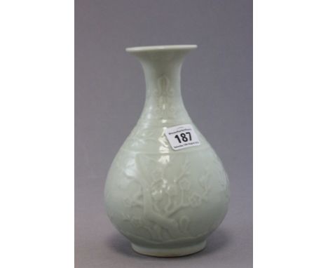 A Chinese porcelain light green celadon vase, of bulbous form, with raised blossom decoration, bearing character mark to base