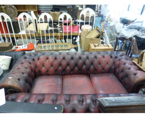 A three seater red leather button back Chesterfield settee