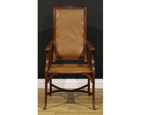 An Arts &amp; Crafts mahogany reclining armchair, the sloping back adjustable on a baton, shaped arms with geometric applique