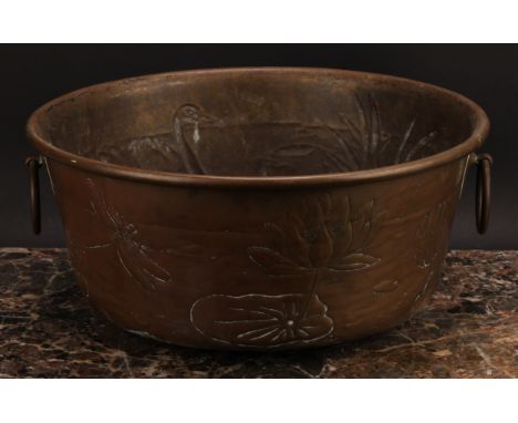 An Arts and Crafts brass two-handled water basin, repousse chased with swans amongst reeds, 34.5cm diam, c.1880