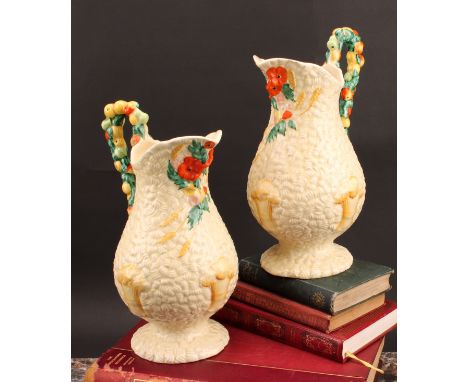 A pair of Clarice Cliff Celtic Harvest pattern jugs, moulded with wheatsheaves on a honey glaze ground, each handle as a garl