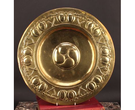 An Arts and Crafts brass charger, possibly Scottish Glasgow School, repousse chased with an alternating band of fruit and hea