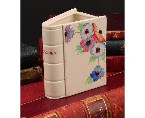 A Clarice Cliff Memories book vase, hand painted with flowers, the spine inscribed ‘Memories’, 12cm high