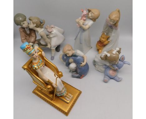 Four Spanish Nao porcelain figures; girl cuddling a blue rabbit; Disney Collection, child cuddling Eeyore; girl holding Winni