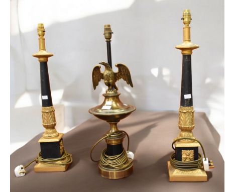 A pair of regency style black and gilt table lamps along with a French Napoleonic style table lamp with eagle detail.