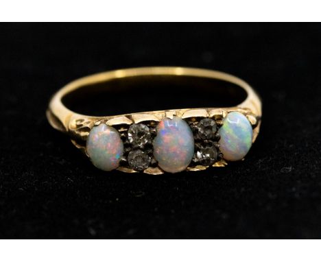 An opal and diamond 18ct gold ring, comprising three oval graduated opals with diamond set accents, width approx 5mm, size N1